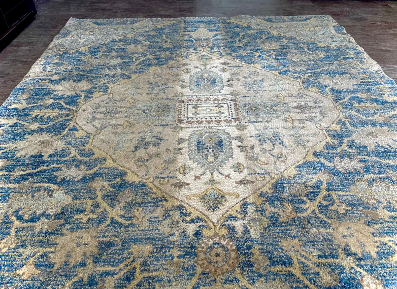 blue, gold and cream rug on hardwood floor