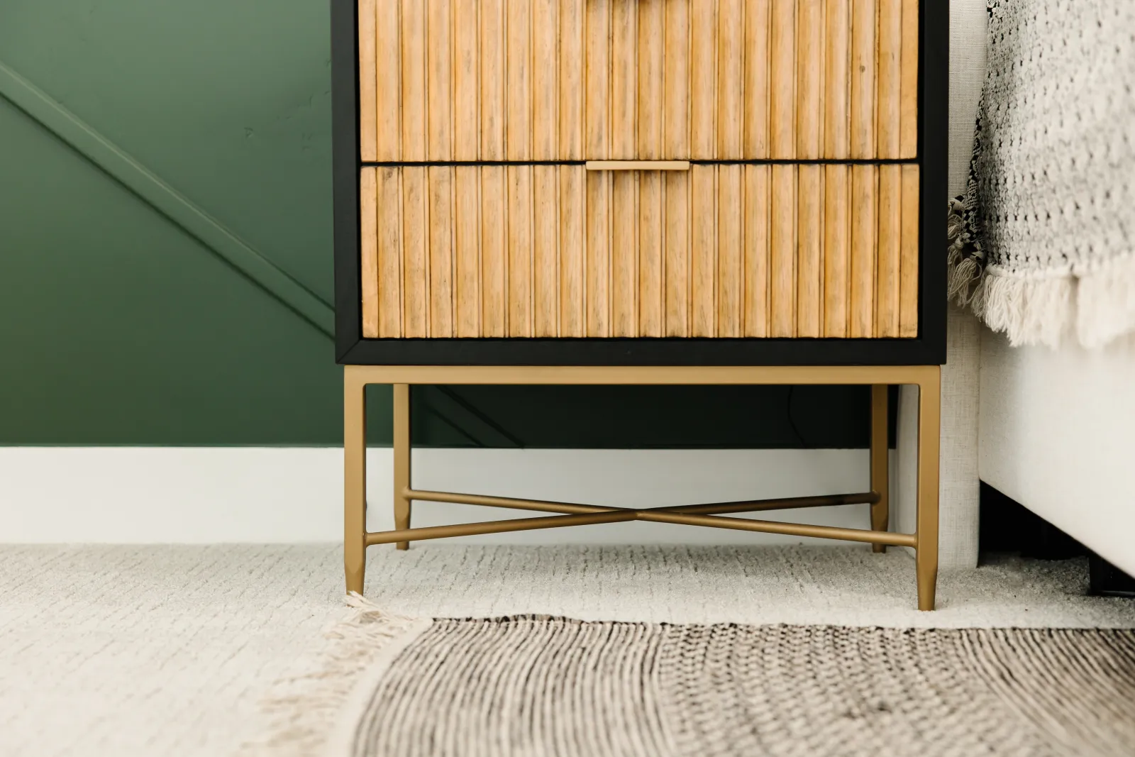 a night stand on carpet with a rug nearby