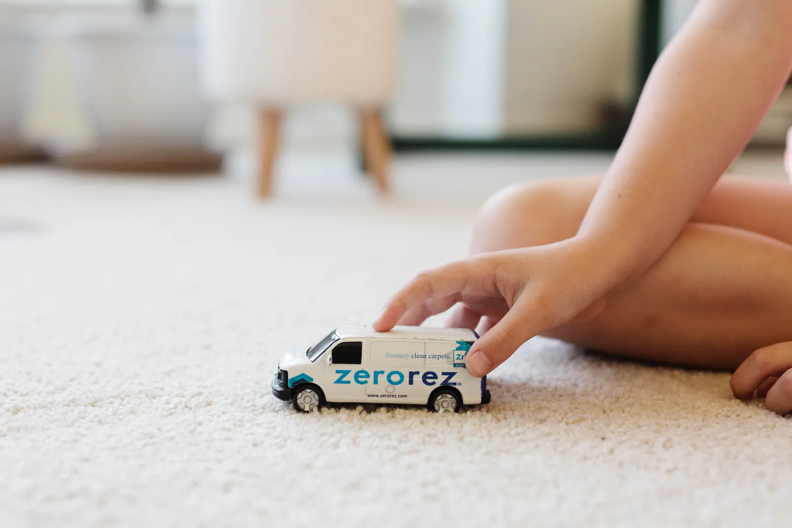 kid playing on carpet with a toy van